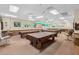 Recreation room with multiple billiards tables, cushioned bar stool seating, and wainscoting at 5500 Laver St, Leesburg, FL 34748