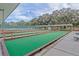 Outdoor bocce ball courts, benches, and a covered seating area with a tennis court in the background at 5500 Laver St, Leesburg, FL 34748