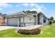 Attractive single-story home with a two-car garage, landscaped yard, and decorative accents at 5500 Laver St, Leesburg, FL 34748