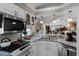 Eat-in kitchen with white cabinets, stone countertops, and modern stainless-steel appliances at 5500 Laver St, Leesburg, FL 34748