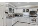 Bright kitchen features white cabinets, modern appliances, a tile backsplash, and a tiled floor at 5500 Laver St, Leesburg, FL 34748