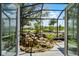 Relaxing screened patio view with custom rock waterfall feature and lush landscaping at 5500 Laver St, Leesburg, FL 34748