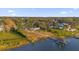 Aerial view of the water, dock, and the home surrounded by green trees at 5526 Parkdale Dr, Orlando, FL 32839
