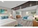 Bright bedroom featuring two beds with neutral decor, wood-look flooring, and exposed beams at 5526 Parkdale Dr, Orlando, FL 32839