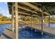 View looking up from the water to the wooden dock and the roof over it at 5526 Parkdale Dr, Orlando, FL 32839