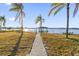 Picturesque waterfront property with a private dock and gazebo, framed by swaying palm trees and a serene view at 5526 Parkdale Dr, Orlando, FL 32839