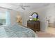 Bedroom with wood bed frame, ceiling fan, and large dresser at 5596 Cedar Waxwing Dr, The Villages, FL 32163