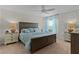 Cozy bedroom featuring a wood bed frame, blue bedding, and neutral walls at 5596 Cedar Waxwing Dr, The Villages, FL 32163
