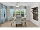 The dining room has a round table, four chairs and bright natural lighting at 5596 Cedar Waxwing Dr, The Villages, FL 32163