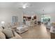 Bright living room flowing into kitchen, with hardwood floors, neutral decor, and abundant natural light at 5596 Cedar Waxwing Dr, The Villages, FL 32163