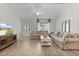 Comfortable living room featuring hardwood floors, cozy couches, and a welcoming atmosphere for relaxation at 5596 Cedar Waxwing Dr, The Villages, FL 32163