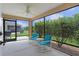 Relaxing screened patio with ceiling fan and comfortable seating overlooking lush greenery at 5596 Cedar Waxwing Dr, The Villages, FL 32163