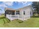 Home featuring a screened-in porch and white picket fence surrounding a well-maintained lawn at 744 Shelton St, The Villages, FL 32163