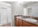 Well-lit bathroom featuring a double sink vanity and glass door shower at 744 Shelton St, The Villages, FL 32163