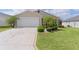Home with a unique compass rose driveway, attached garage, and manicured landscaping at 744 Shelton St, The Villages, FL 32163