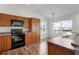 Well-lit kitchen features wood cabinets, black appliances, and adjacent dining area at 744 Shelton St, The Villages, FL 32163