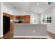 Kitchen with wood cabinets, black appliances, and breakfast bar at 744 Shelton St, The Villages, FL 32163