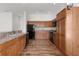 Kitchen featuring wood cabinets, black appliances, and plenty of counter space at 744 Shelton St, The Villages, FL 32163
