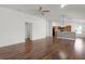 Open living room with hardwood floors leading to the kitchen and a ceiling fan at 744 Shelton St, The Villages, FL 32163