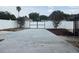Wide driveway leading to a secure gate, surrounded by a well-maintained yard and mature trees at 8025 Cardinal Winds Ln, Mascotte, FL 34753