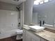Bathroom boasts a granite countertop vanity with bowl sink, framed mirror, and shower-tub combination at 8025 Cardinal Winds Ln, Mascotte, FL 34753