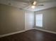 Bedroom features a ceiling fan, neutral walls, wood-look floors, and a closet at 8025 Cardinal Winds Ln, Mascotte, FL 34753