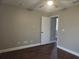 Bedroom features neutral walls, wood-look floors, a ceiling fan, and an ensuite at 8025 Cardinal Winds Ln, Mascotte, FL 34753