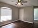 Comfortable bedroom featuring wood floors, a ceiling fan, and a window with natural light at 8025 Cardinal Winds Ln, Mascotte, FL 34753