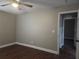 Bedroom features neutral walls, wood-look floors, a ceiling fan, and an ensuite at 8025 Cardinal Winds Ln, Mascotte, FL 34753
