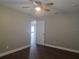 Bedroom boasts a ceiling fan, neutral walls, wood-look floors, and ensuite access at 8025 Cardinal Winds Ln, Mascotte, FL 34753