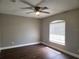 Cozy bedroom with wood floors, a ceiling fan, and a window for natural light at 8025 Cardinal Winds Ln, Mascotte, FL 34753