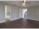 Spacious primary bedroom with wood floors, ceiling fan, ensuite bathroom and walk-in closet at 8025 Cardinal Winds Ln, Mascotte, FL 34753