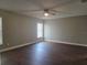 Large bedroom with wood floors, a ceiling fan, two windows for natural light, and neutral paint at 8025 Cardinal Winds Ln, Mascotte, FL 34753