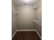 Walk-in closet with wooden floor and white wire shelving for easy storage at 8025 Cardinal Winds Ln, Mascotte, FL 34753