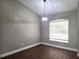 Bright dining area features wood floors, a modern light fixture, and a window with blinds for natural light at 8025 Cardinal Winds Ln, Mascotte, FL 34753