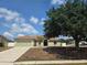 Charming one-story home with a well-kept lawn, featuring a two-car garage and mature landscaping at 8025 Cardinal Winds Ln, Mascotte, FL 34753