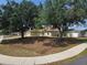 Lovely one-story home with mature trees, featuring a two-car garage, green lawn, and charming curb appeal at 8025 Cardinal Winds Ln, Mascotte, FL 34753