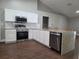 Kitchen with a large island with seating, white cabinets, and stainless steel appliances at 8025 Cardinal Winds Ln, Mascotte, FL 34753