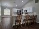 Kitchen with a large island with seating, white cabinets, and stainless steel appliances at 8025 Cardinal Winds Ln, Mascotte, FL 34753