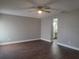 Generous main bedroom with wood floors, neutral paint, and an ensuite bathroom at 8025 Cardinal Winds Ln, Mascotte, FL 34753