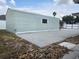Detached shed in backyard offers additional storage space, complemented by a concrete pad and rock landscaping at 8025 Cardinal Winds Ln, Mascotte, FL 34753