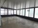 Bright sunroom featuring glass windows and concrete floor at 8025 Cardinal Winds Ln, Mascotte, FL 34753