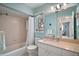 Light blue bathroom with tub and shower combination and large vanity mirror at 809 Northside Dr, Mount Dora, FL 32757