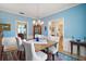 Inviting dining room with blue accent walls, chandelier, and wood table set upon a patterned rug at 809 Northside Dr, Mount Dora, FL 32757