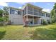 Back of the house featuring a screened porch, under-deck patio, and green yard at 809 Northside Dr, Mount Dora, FL 32757