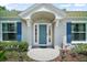 Charming entryway with sidelights, blue shutters, and a well-manicured garden at 809 Northside Dr, Mount Dora, FL 32757