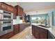 Spacious kitchen featuring dark wood cabinets, modern appliances, and a large window with scenic views at 809 Northside Dr, Mount Dora, FL 32757