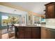 Open-concept kitchen with an island, wood cabinets, and view of the dining area and backyard at 809 Northside Dr, Mount Dora, FL 32757