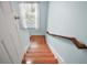 Bright staircase features wood steps, a handrail, and a window with natural light filtering in at 809 Northside Dr, Mount Dora, FL 32757