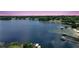 Scenic aerial view of a large lake featuring a dock and beautiful waterfront homes under a colorful sky at 809 Northside Dr, Mount Dora, FL 32757